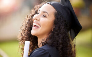 Young lady in graduation robe and hat holding diploma